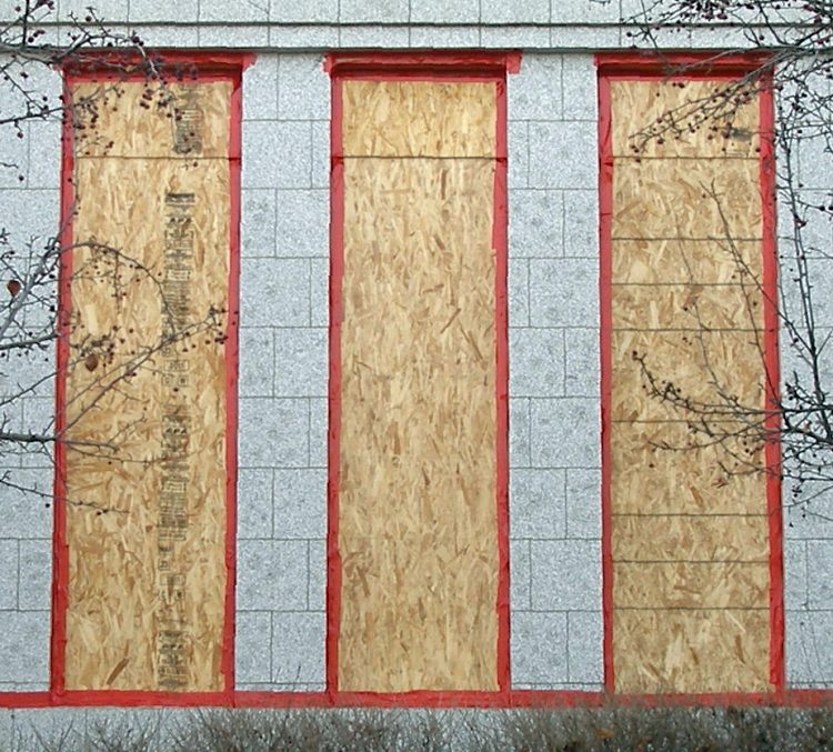 Boarded up window openings, now highlighted with red tape,